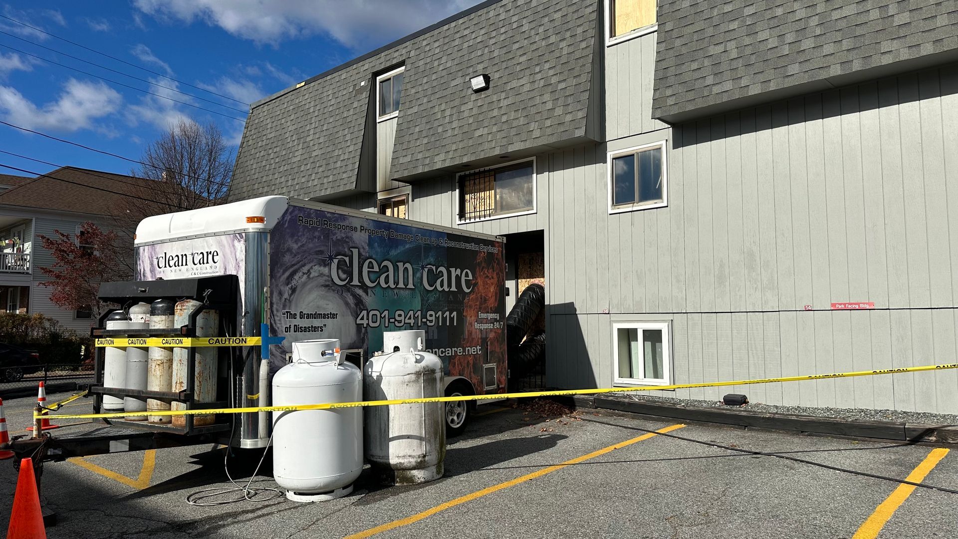 A truck with propane tanks on it is parked in front of a building.