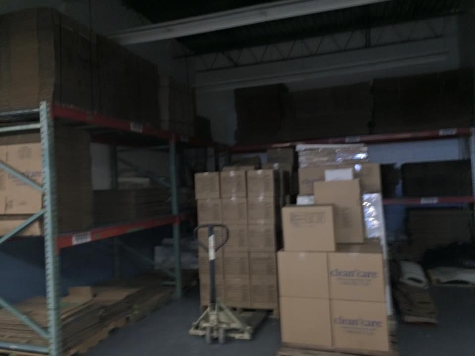 A warehouse filled with lots of boxes and a hand truck