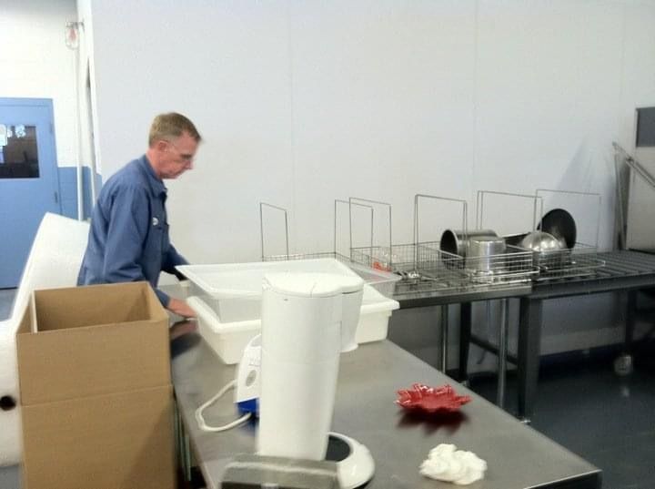 A man in a blue shirt is working in a kitchen