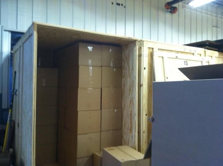 A stack of cardboard boxes in a wooden crate