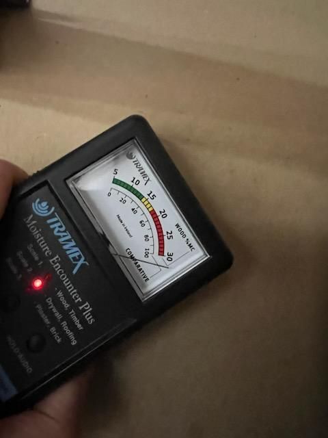 Someone is holding a trumex moisture detector in their hand