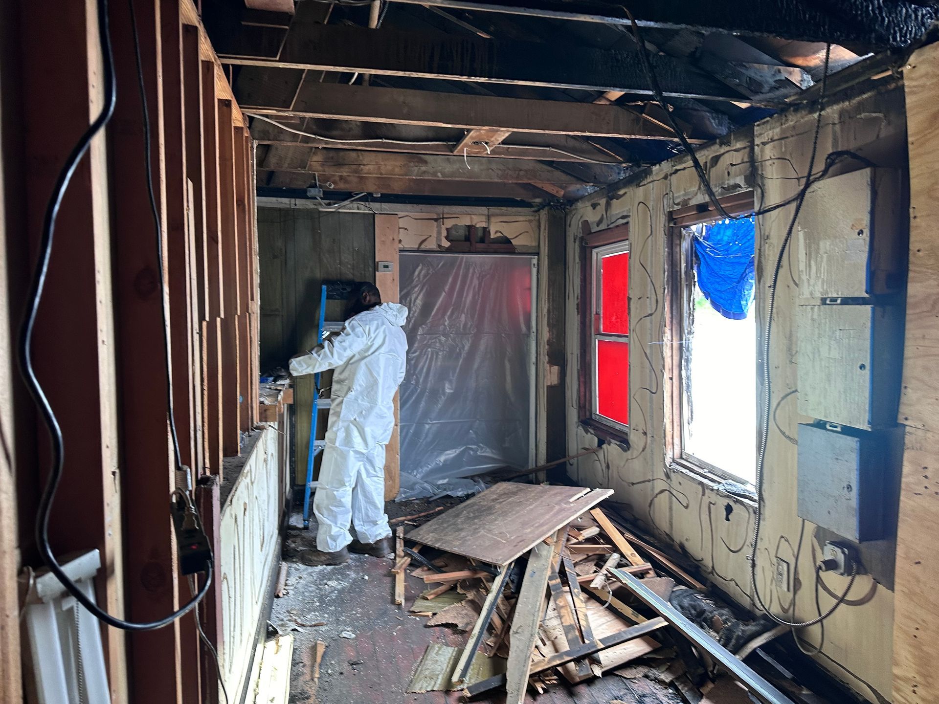 A man in a white suit is working on a building.