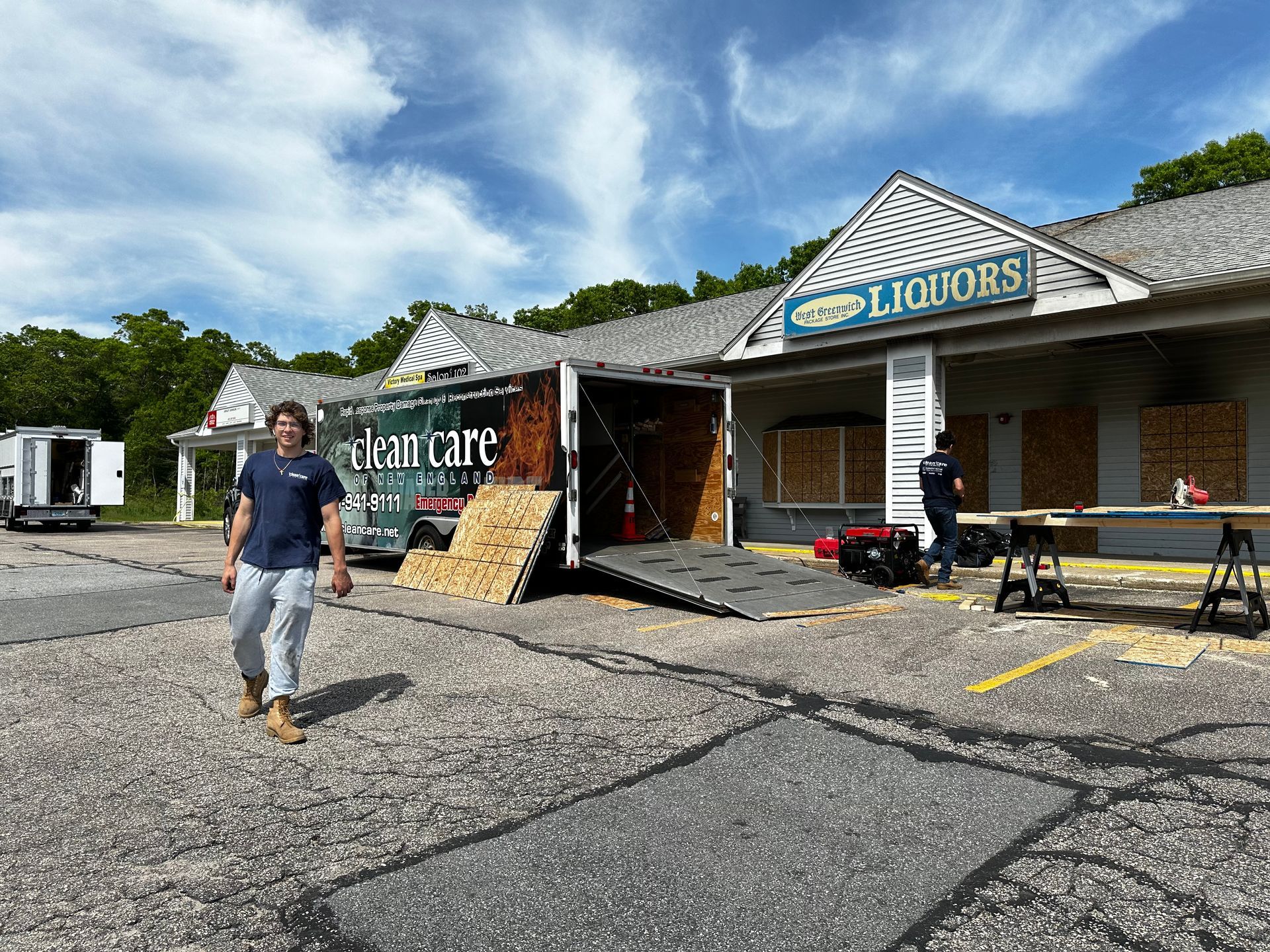 A man is standing in front of a building with a truck parked in front of it.