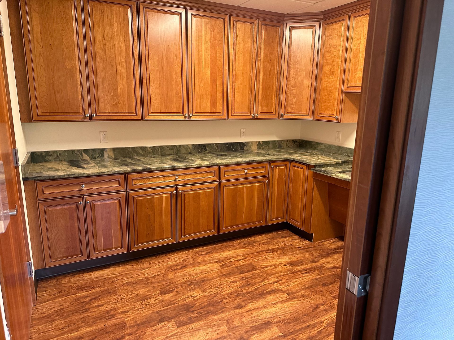 A kitchen with wooden cabinets and granite counter tops.