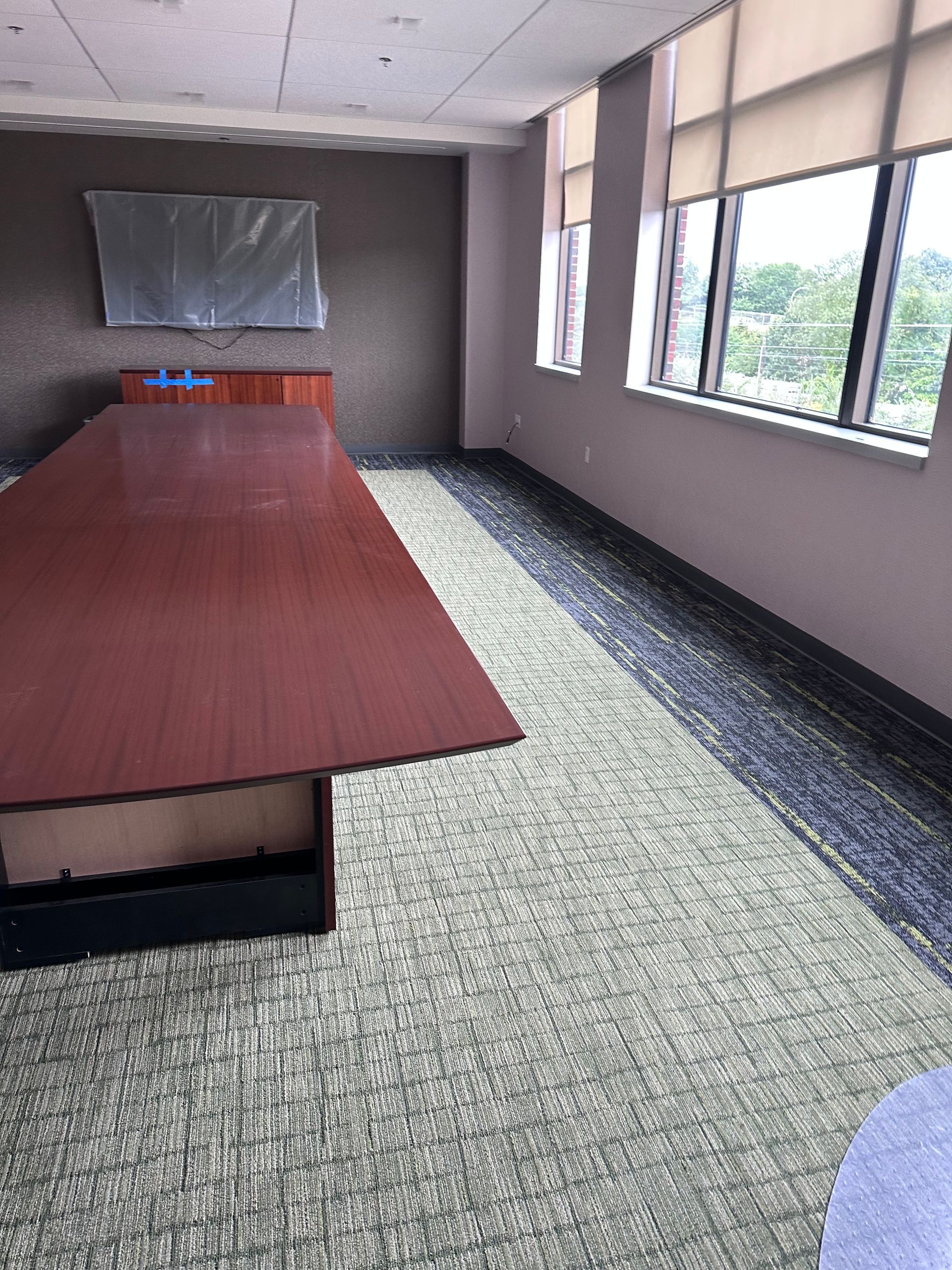 A conference room with a long table and lots of windows