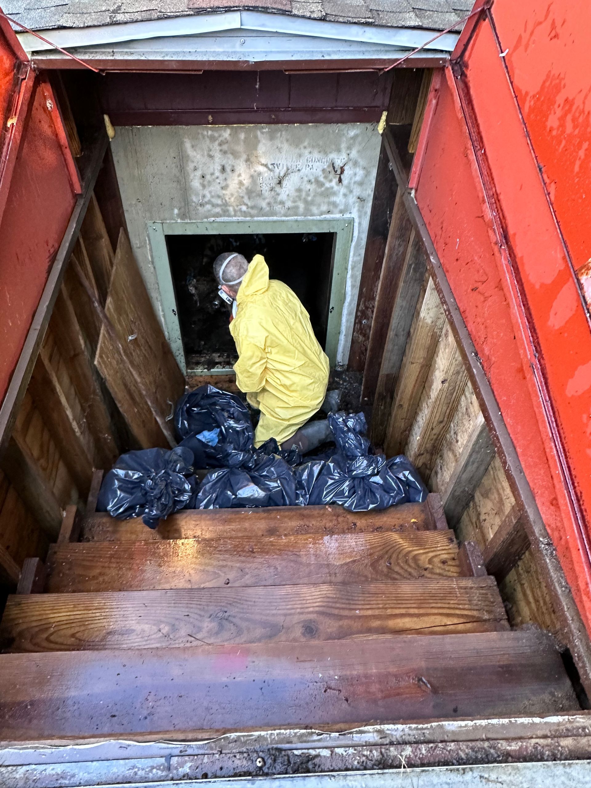 A man in a yellow raincoat is standing in a wooden tunnel.
