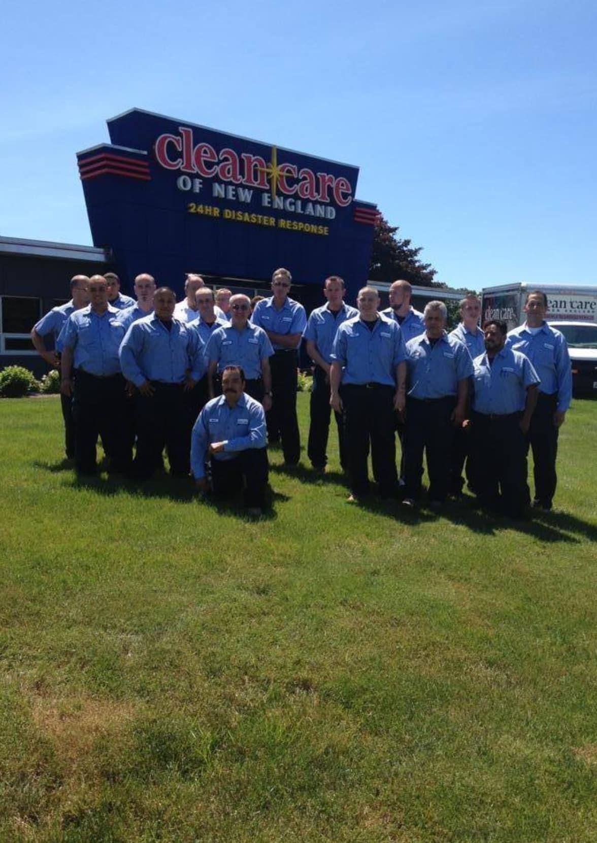 A group of men standing in front of a clean care sign