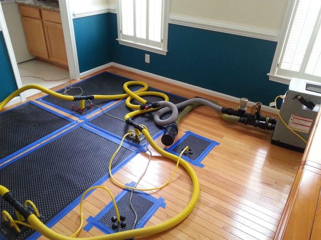A room with a wooden floor and a lot of hose on the floor.