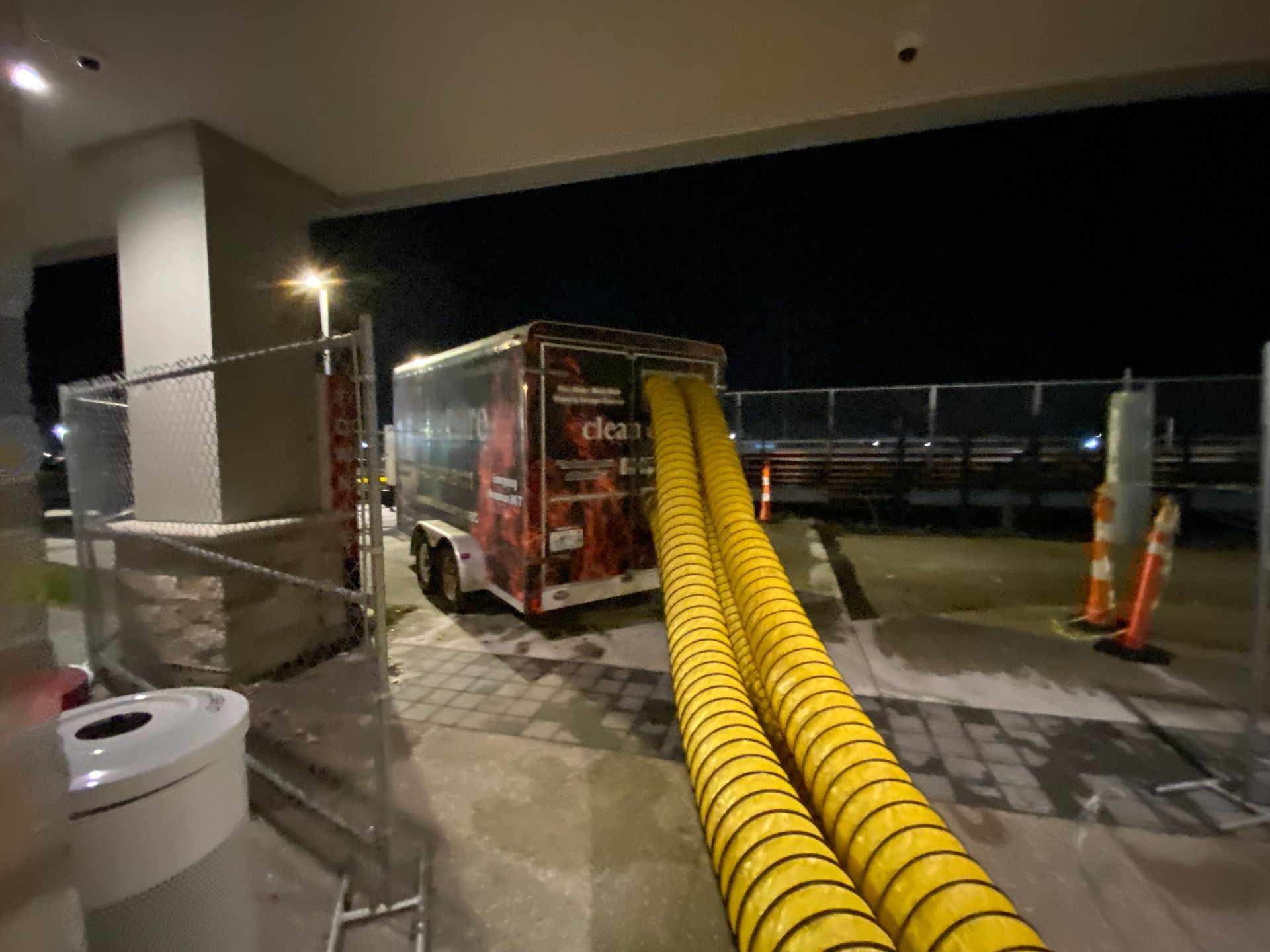 A truck with a hose attached to it is parked in a parking lot.