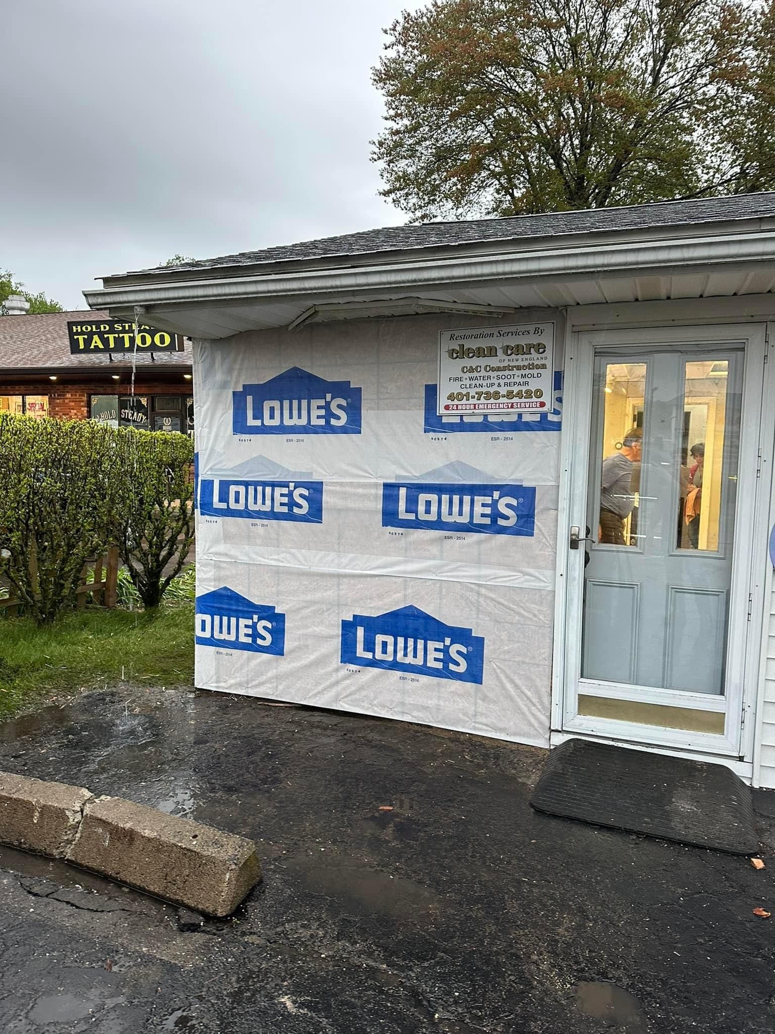 A building with a lot of lowe 's stickers on it is being remodeled.