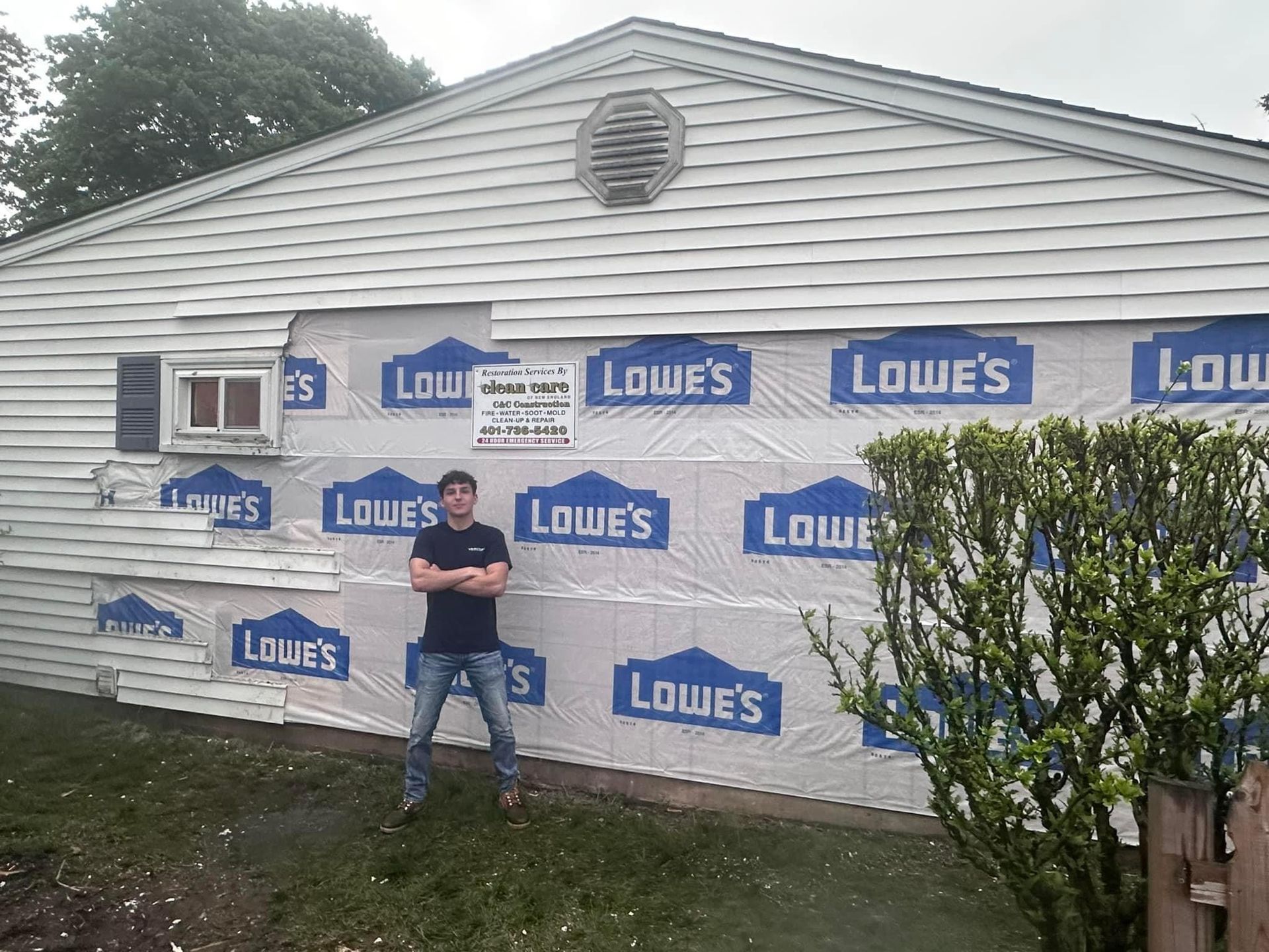 A man is standing in front of a house covered in lowe 's siding.