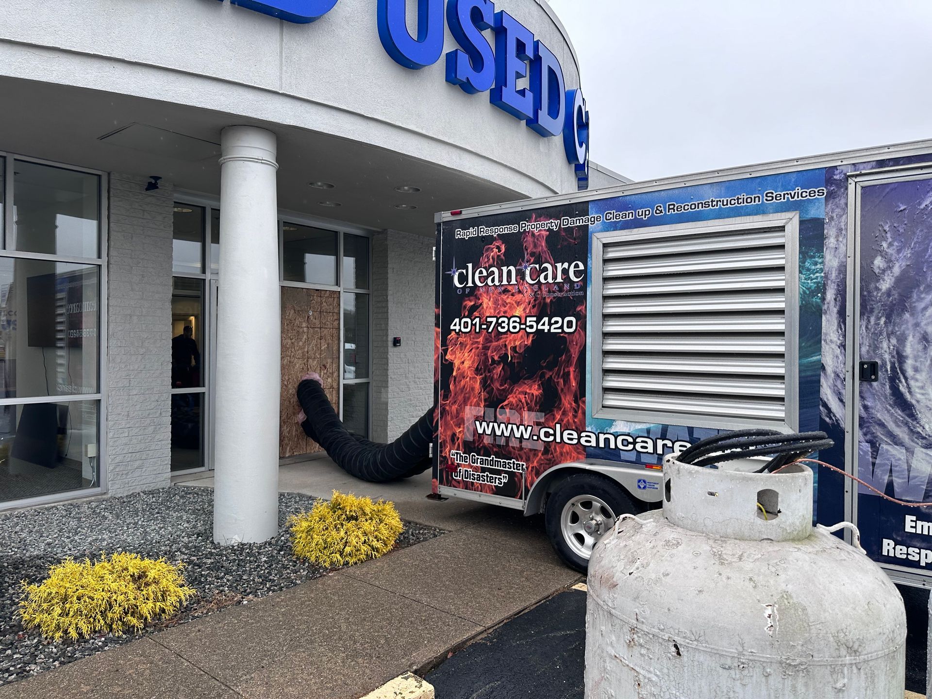 A clean care trailer is parked in front of a building.