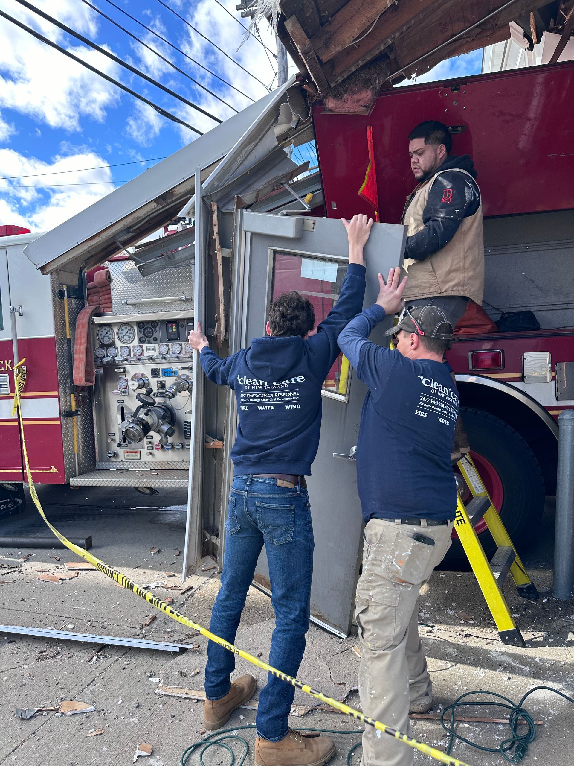 Two men are working on a fire truck.