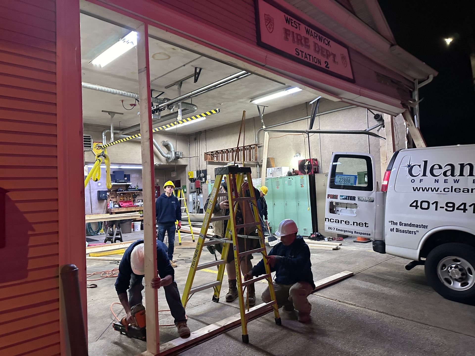 A group of men are working on a garage door.