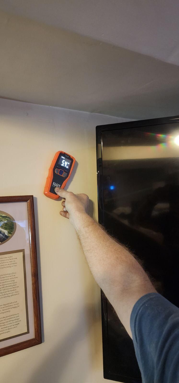 A person is measuring a wall with a laser level.