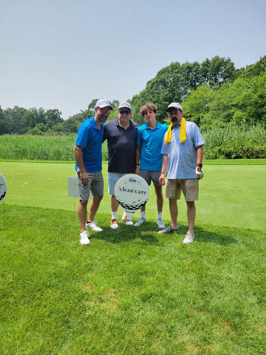 A group of men are posing for a picture on a golf course.