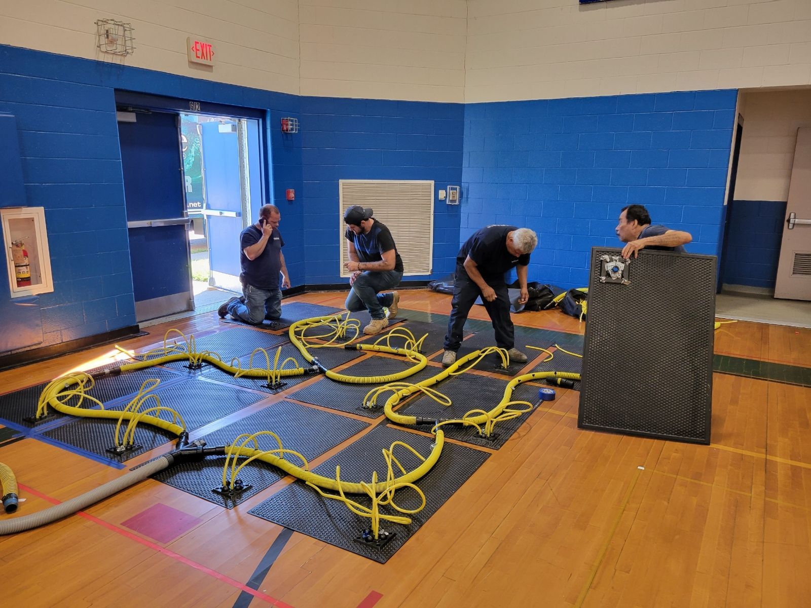 A group of men are working on a track in a gym.