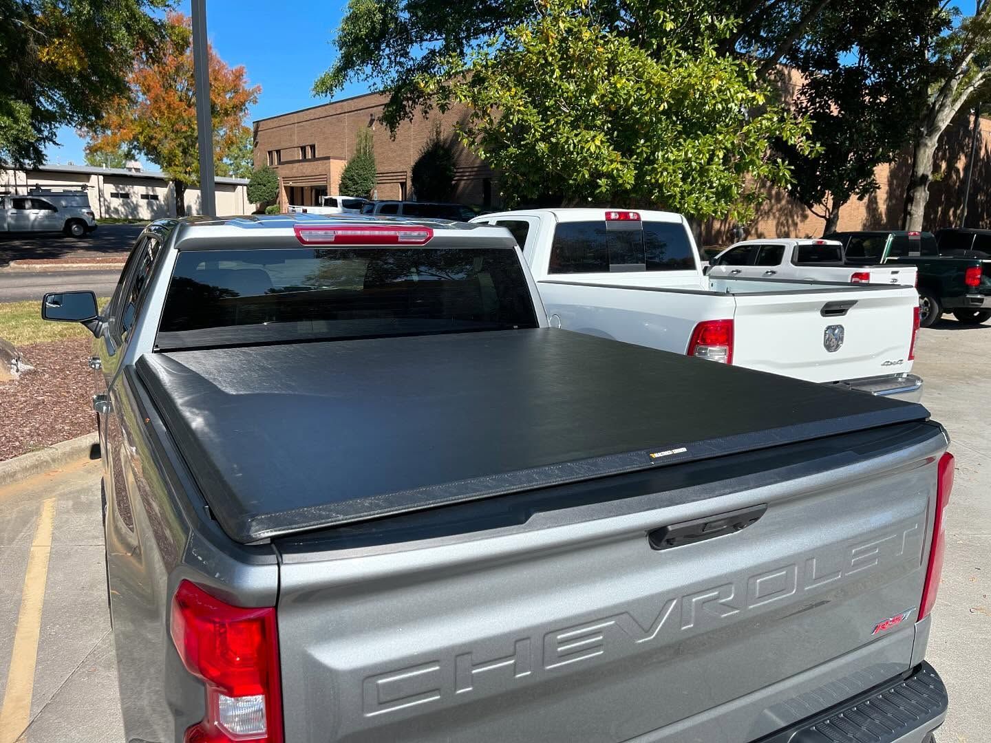 Gray Chevy pickup truck with a black bed cover, parked outdoors.