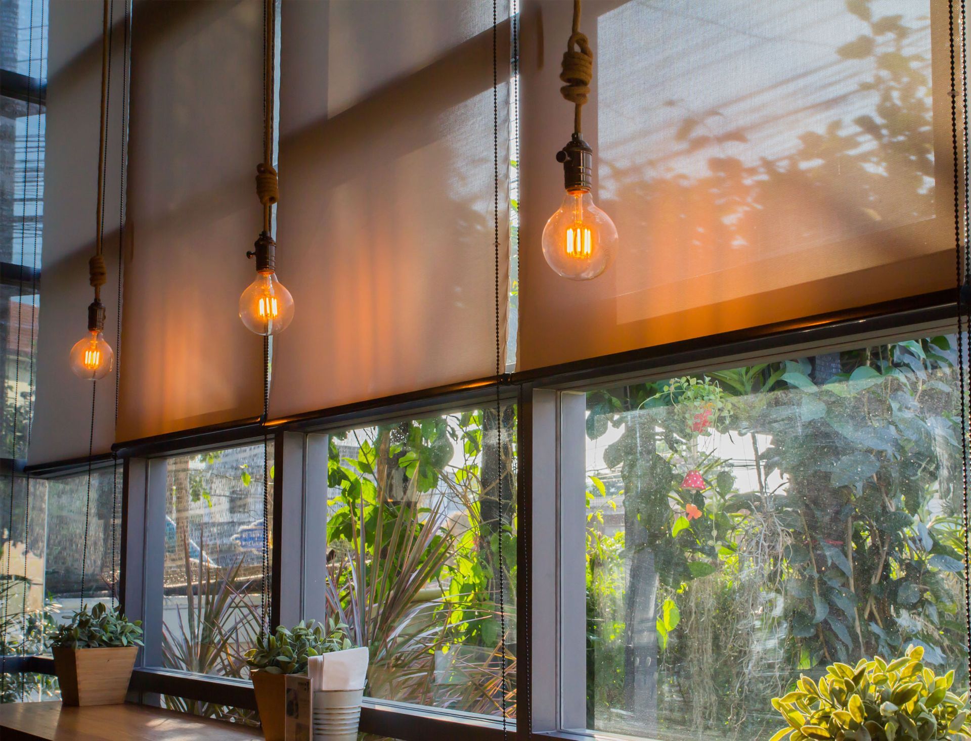 A restaurant with a lot of windows and lights hanging from the ceiling.