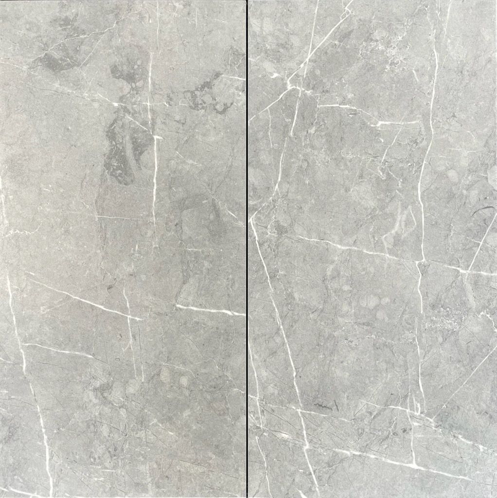 Two adjacent gray marble tiles with white veining.