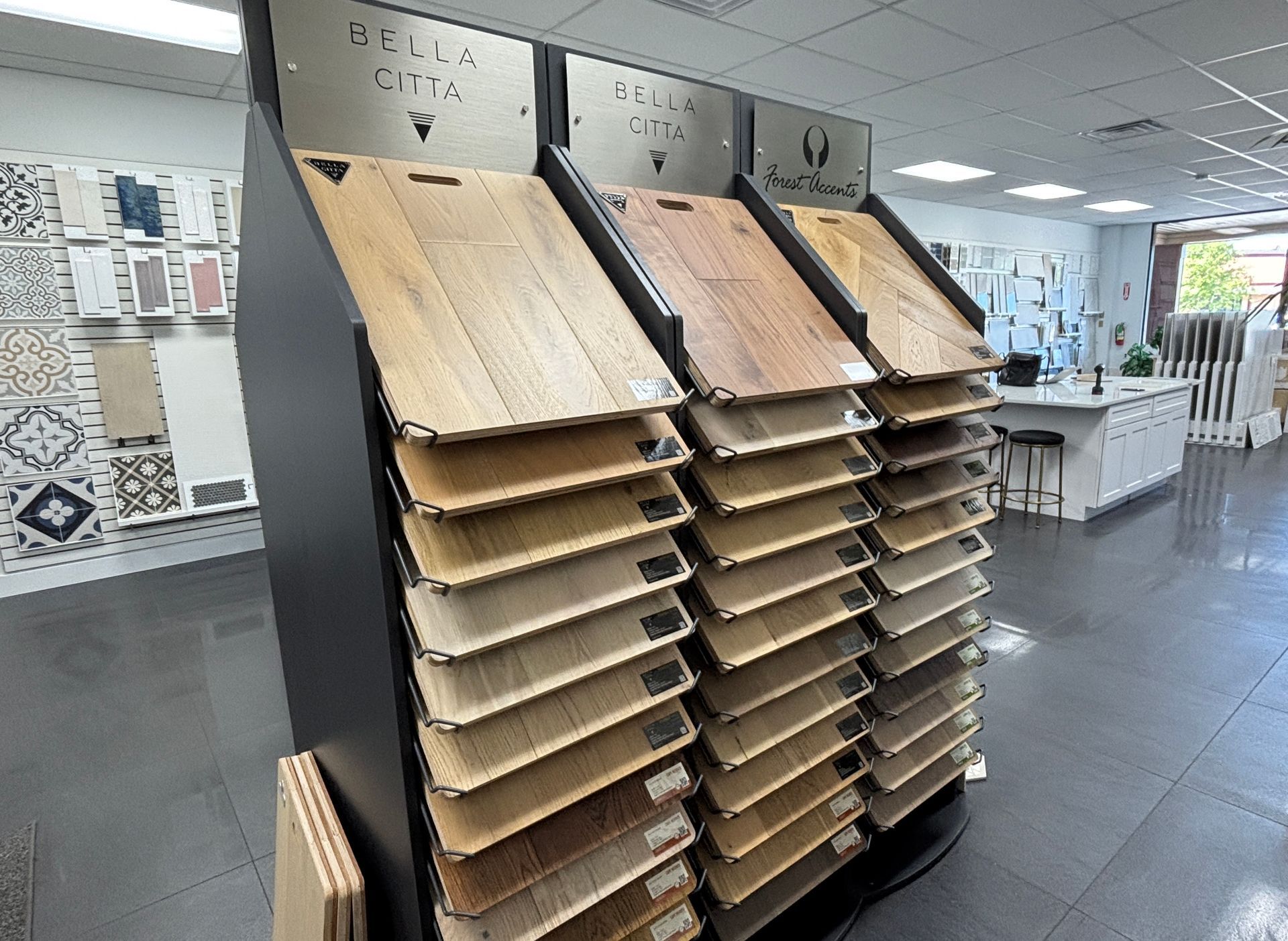 Display of various wood flooring samples in a showroom setting, showcasing different colors and textures.