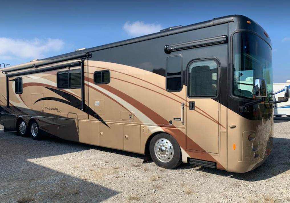a brown and black rv with the word prestige on the side