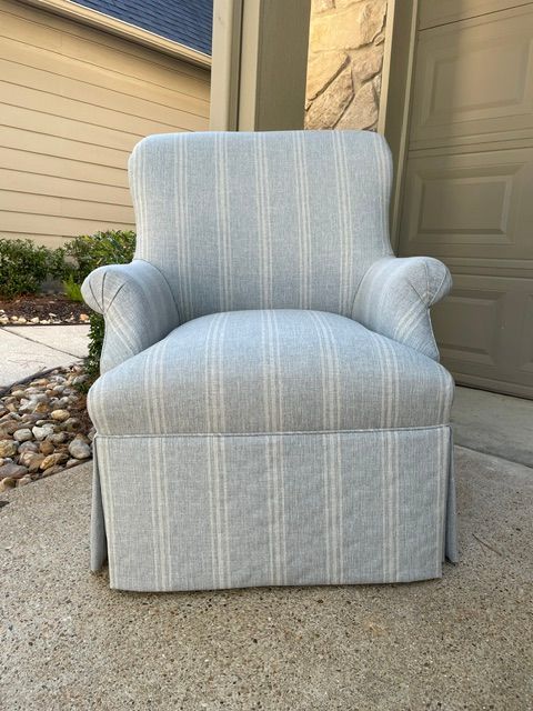 Light blue striped armchair on a concrete patio beside a house entrance