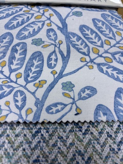 Fabric swatches with a blue and white leaf pattern and a textured blue herringbone.