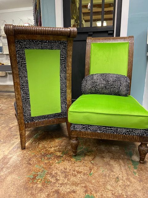 Two chairs, one upright, one reclined, with lime green cushions and backs, surrounded by patterned black and white fabric.