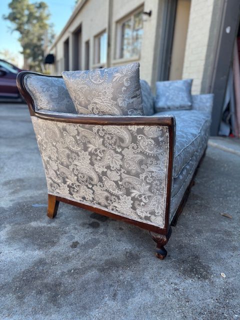 Close-up of fabric swatches. The top one features a blue and white tree print with yellow berries, and the bottom is a blue and green tweed.