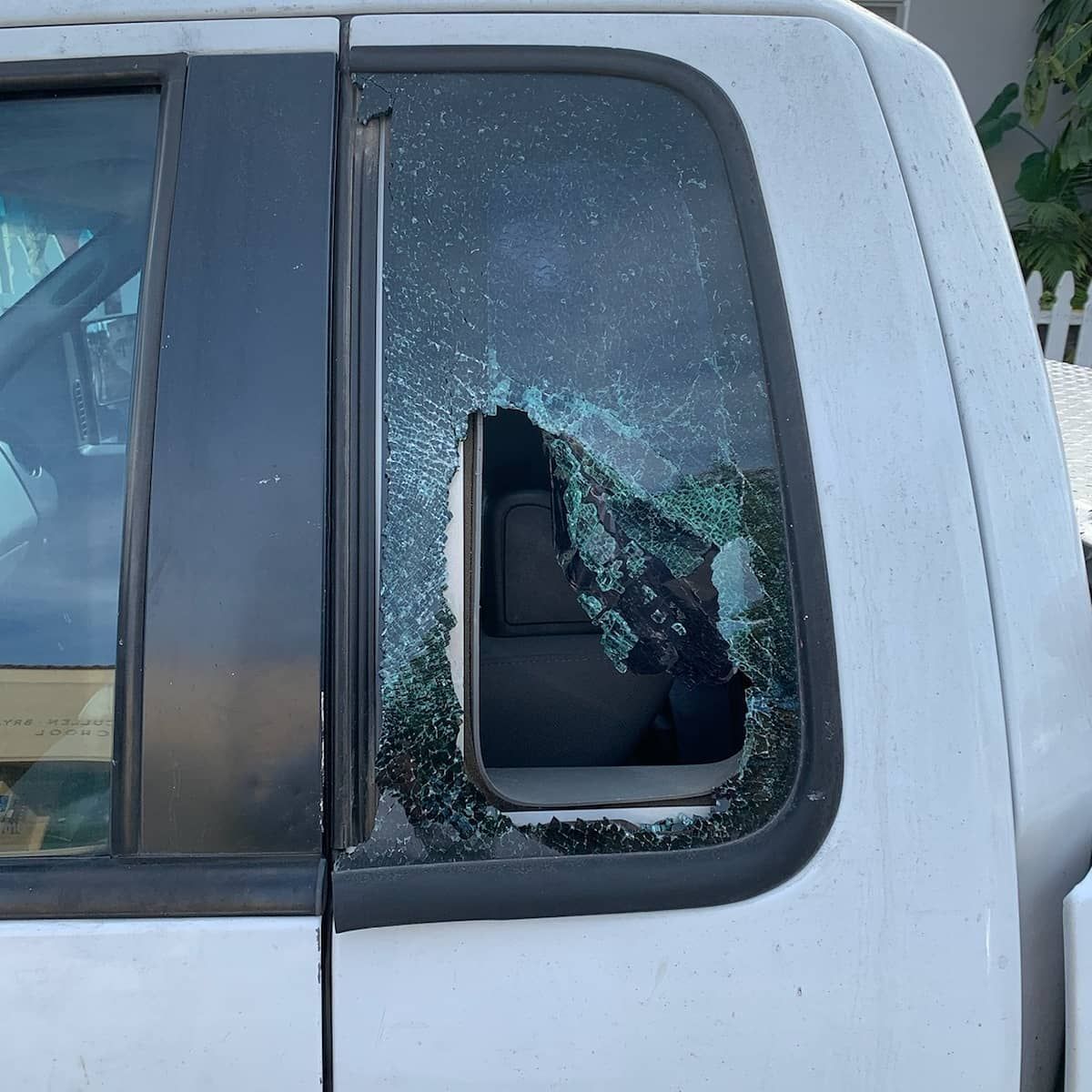 White pickup truck with a shattered rear window.
