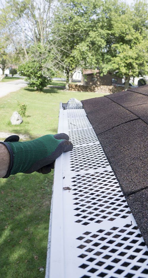 A person is installing a gutter guard on a roof