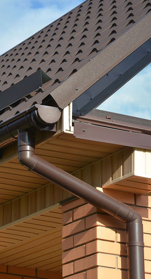 A close up of a gutter on the side of a house