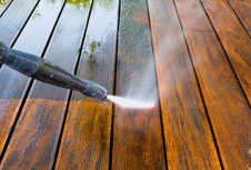 High water pressure cleaner on wooden terrace surface