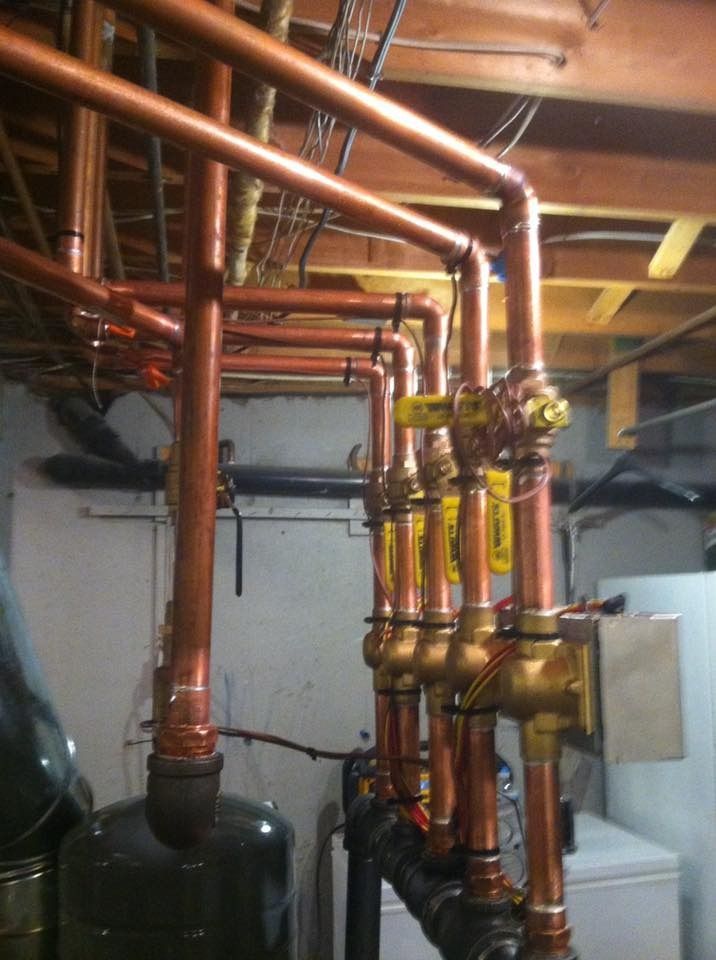 Copper pipes and valves in a basement setting.