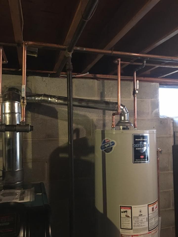 Copper pipes and water heater in a basement.