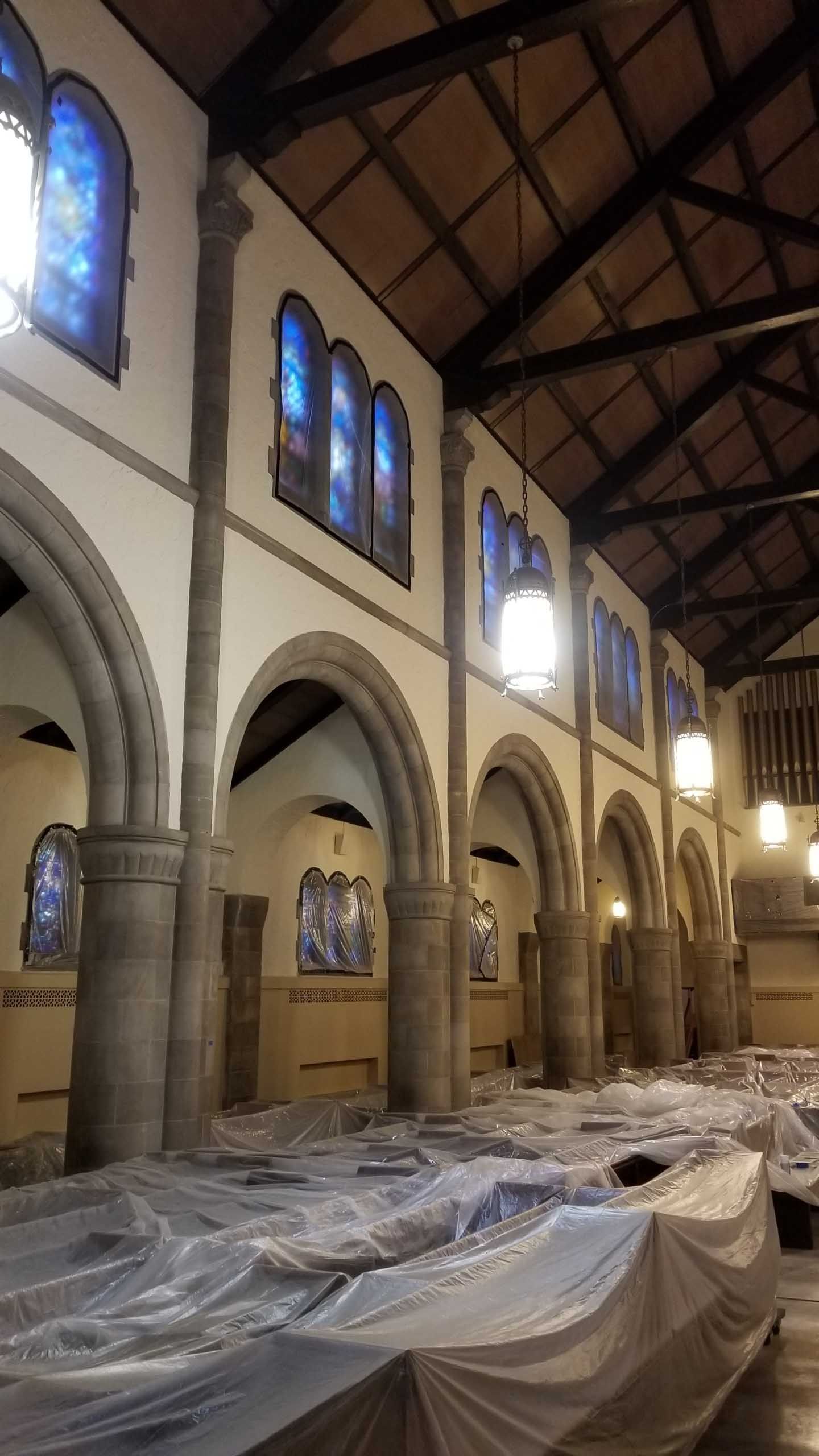 A large room with arches and stained glass windows