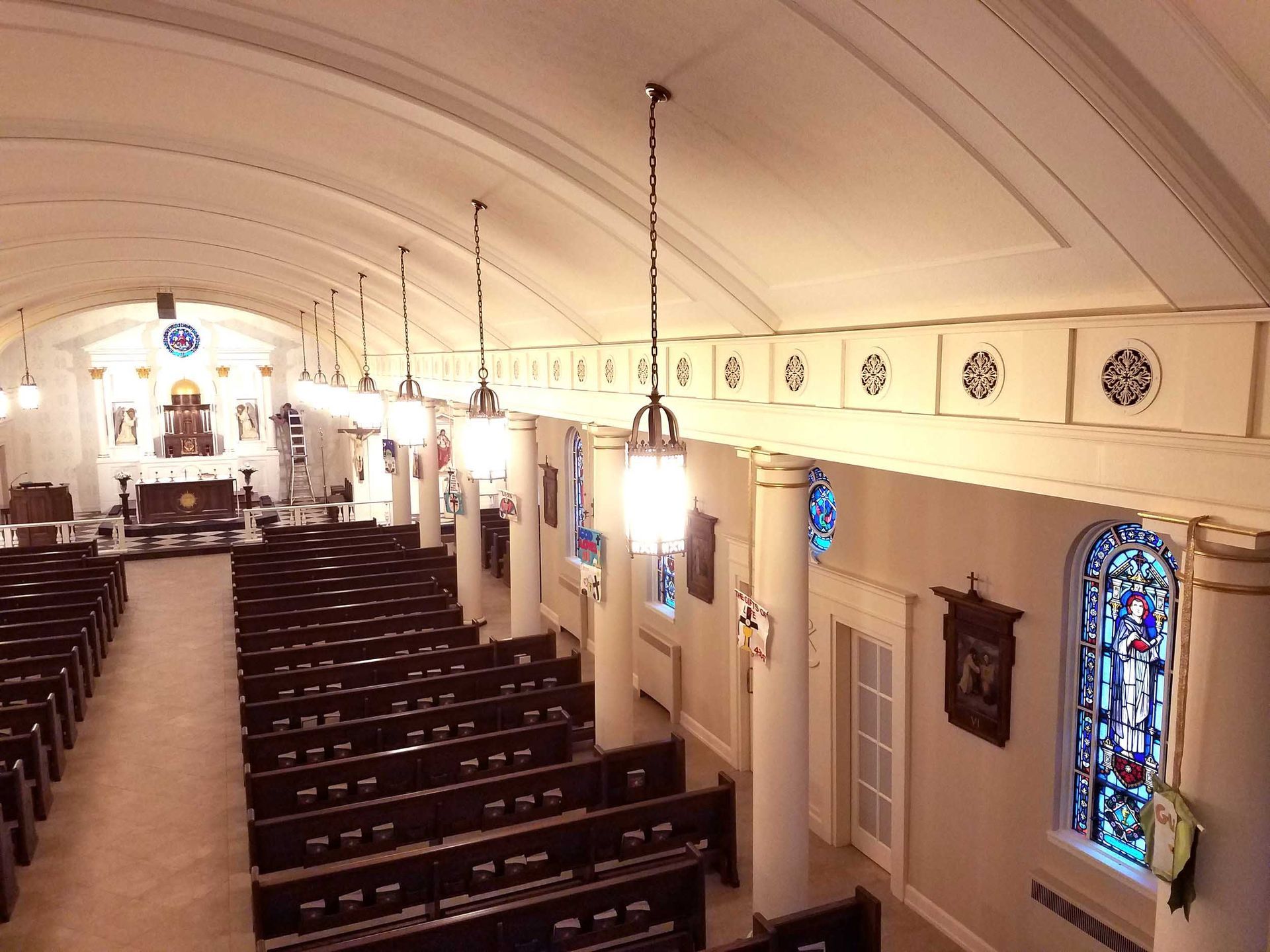 A church with rows of pews and a stained glass window
