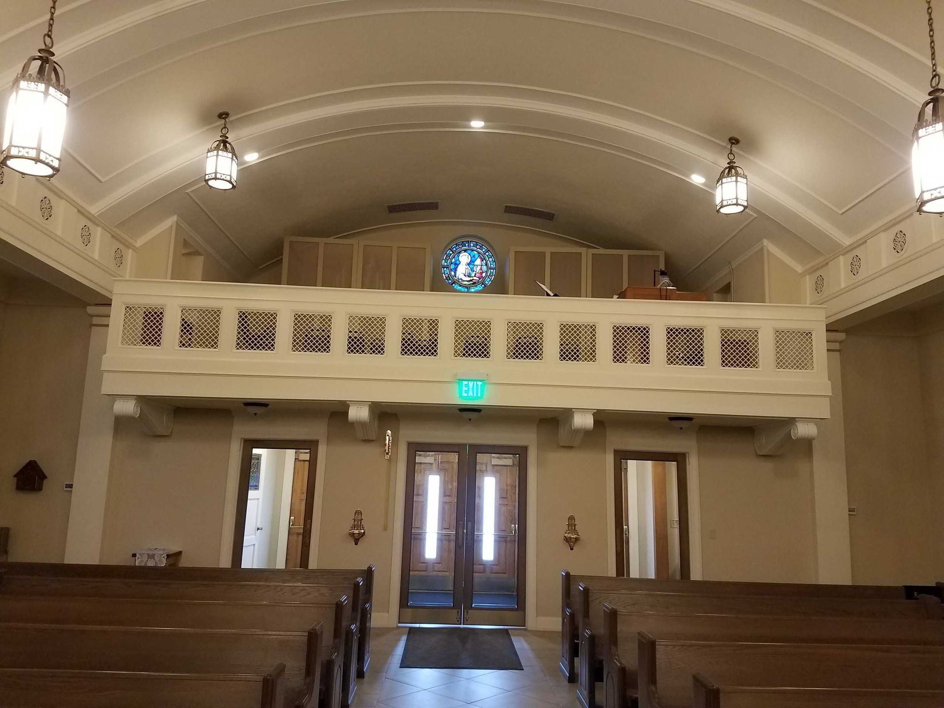 A church with a balcony and a stained glass window
