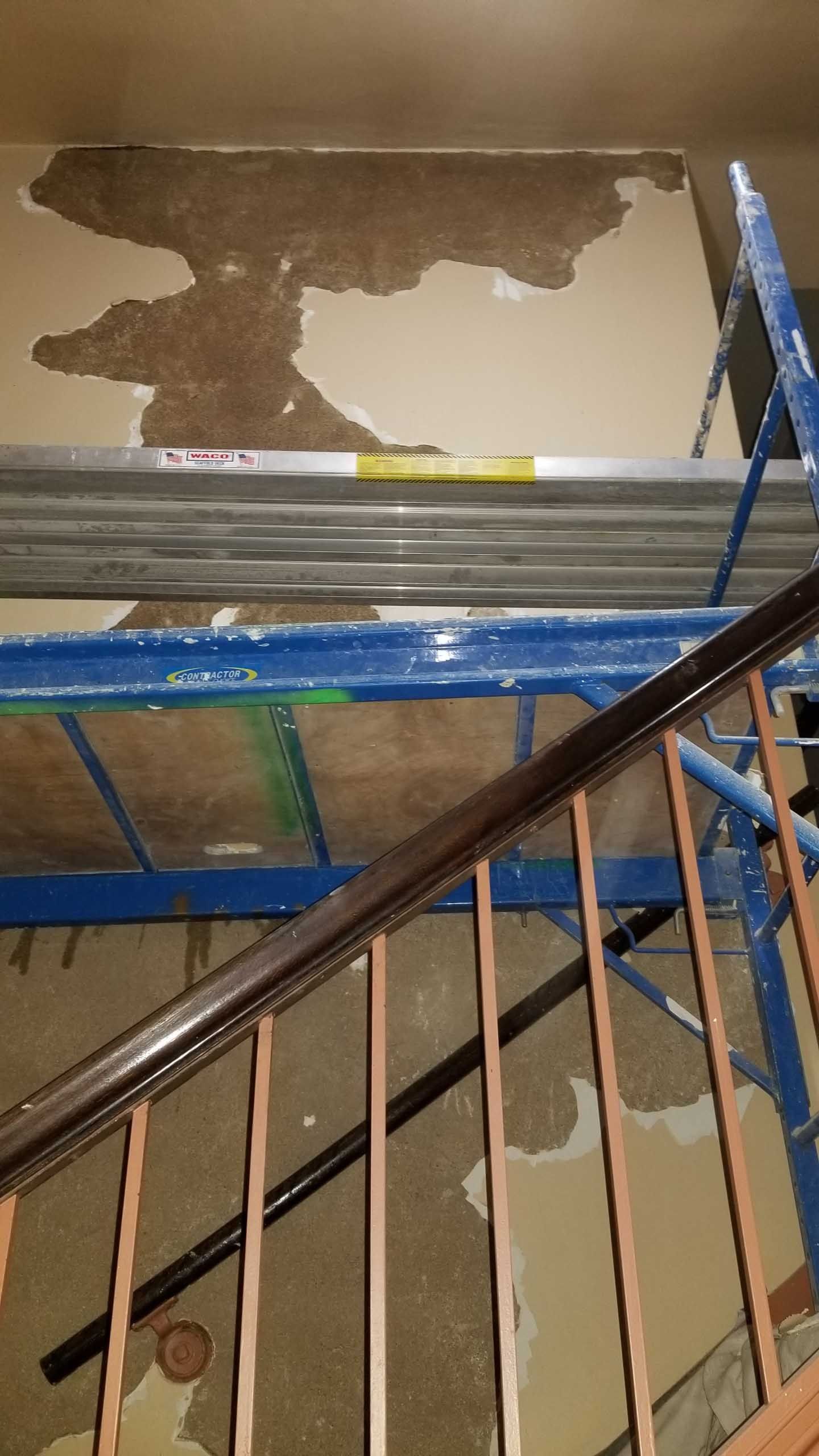 A staircase with a railing and a scaffolding in the background.