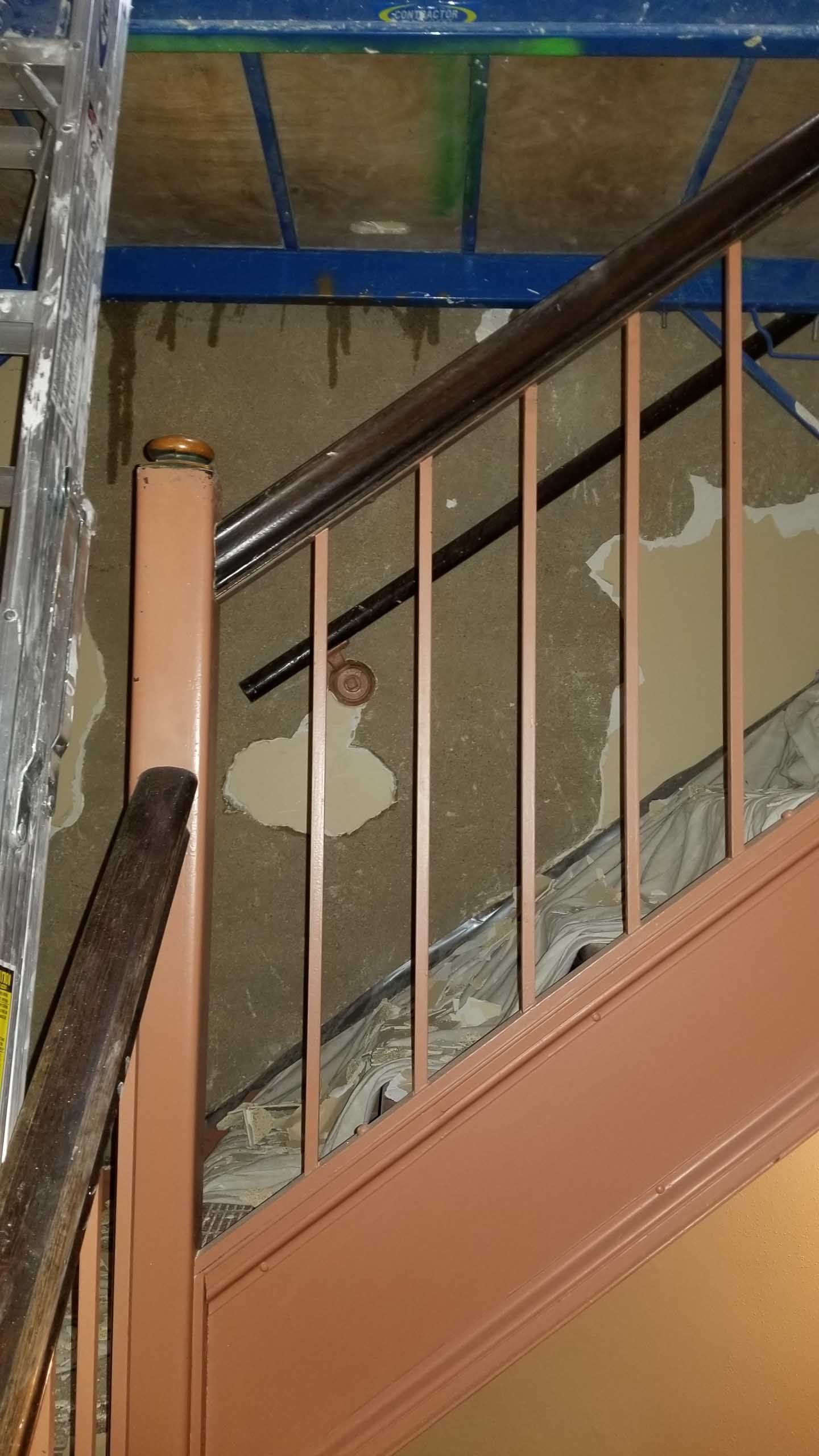 A close up of a staircase with a wooden railing