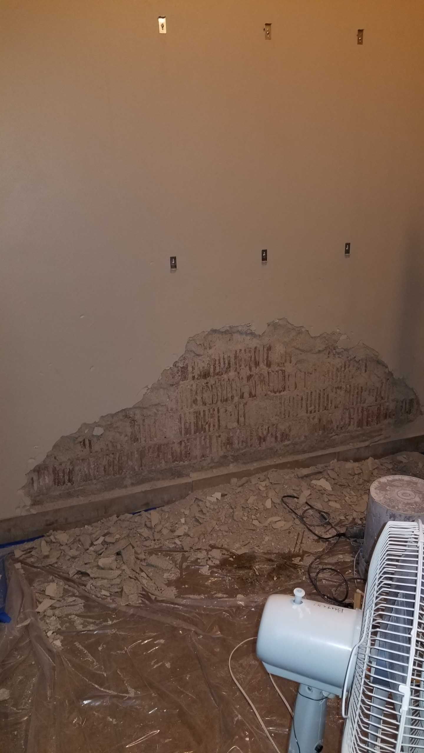 A room with a fan and a piece of plastic on the floor.