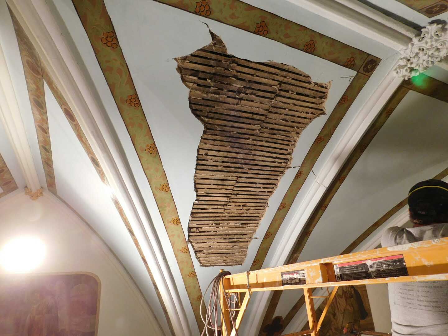 A ceiling with a hole in it and a green light