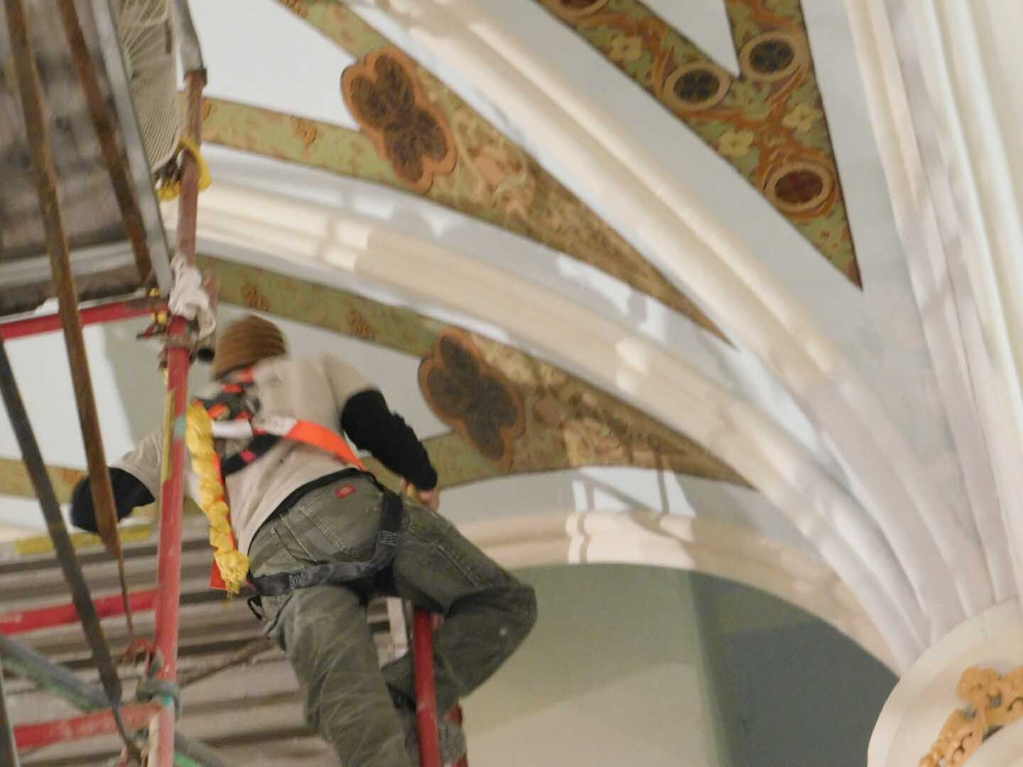 A man is standing on a ladder in a building