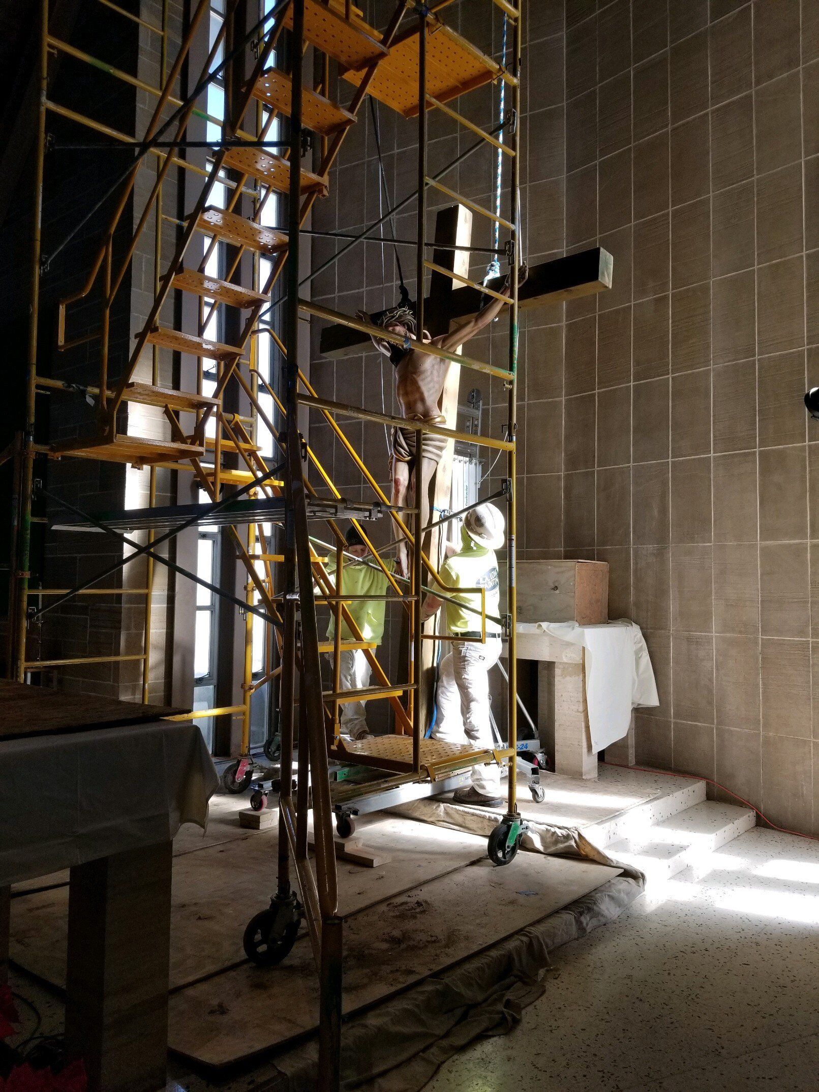 A church under construction with scaffolding and a cross