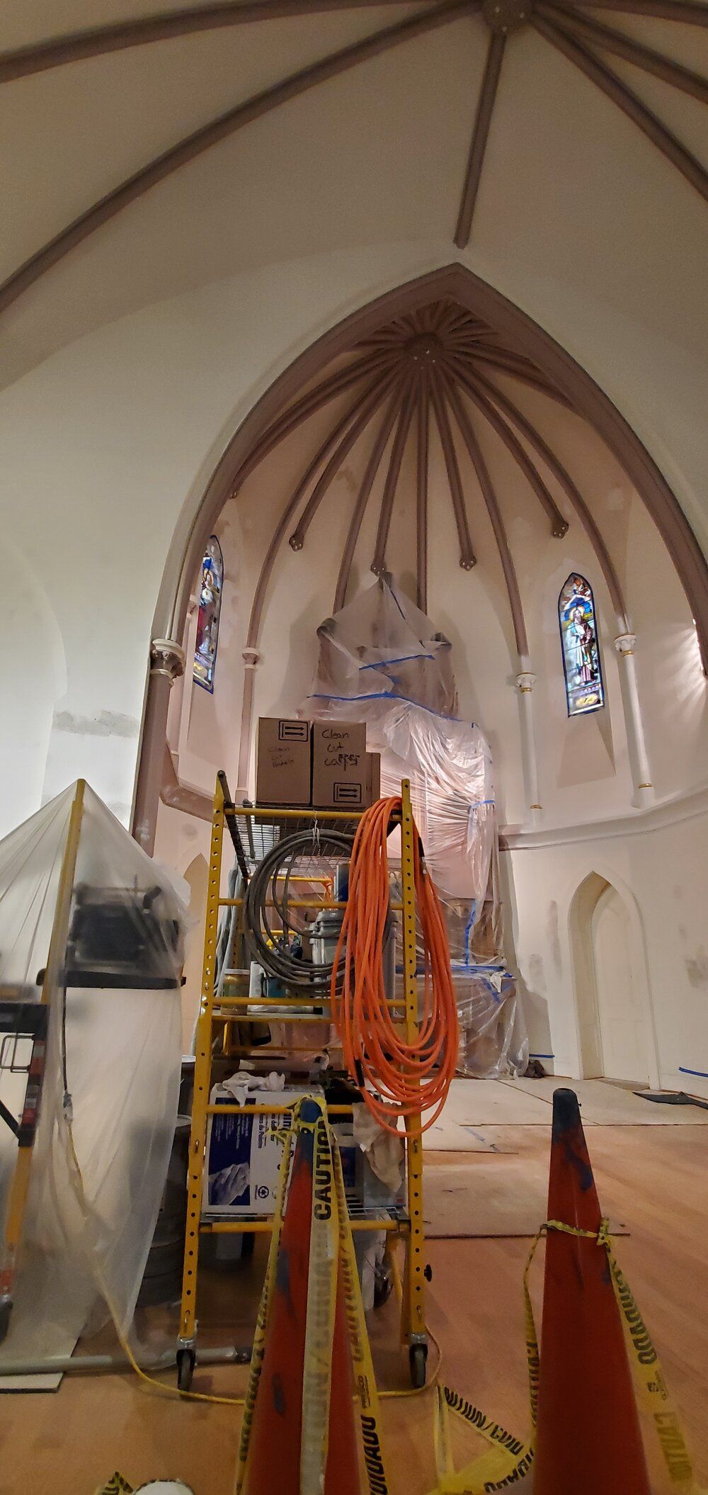 A church is being remodeled and there is a ladder in the middle of the room.