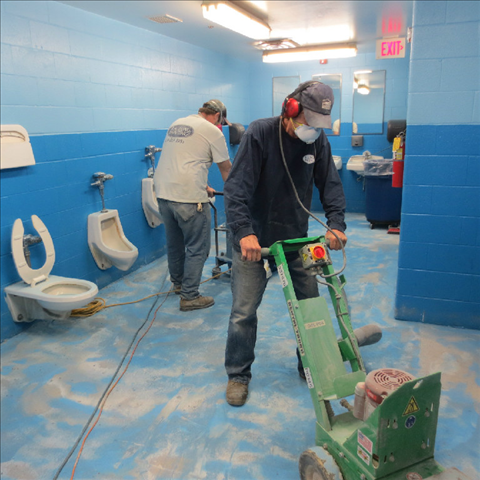 A man wearing a mask is using a machine in a bathroom