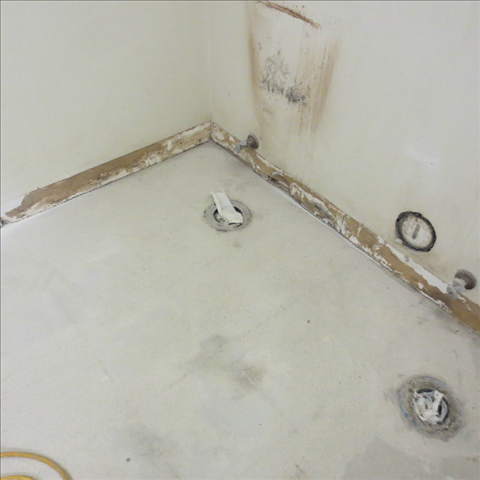 A corner of a bathroom with a clock on the wall