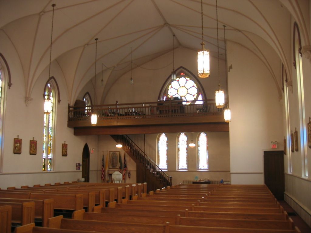 The inside of a church with a balcony and stained glass windows