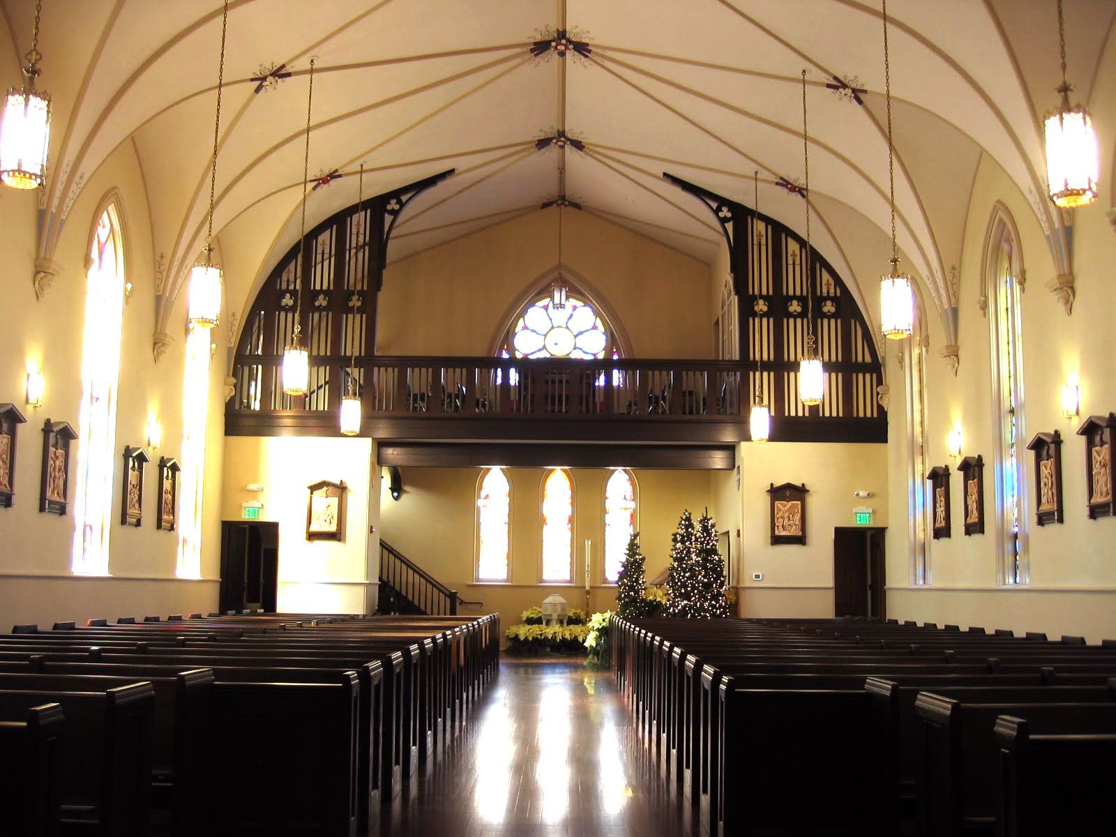 The inside of a church with rows of pews and a balcony